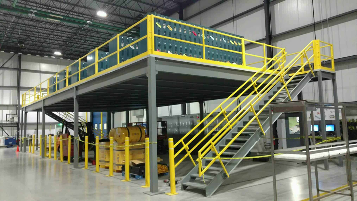 a staircase leading up to an elevated mezzanine with storage underneath, inside of a warehouse